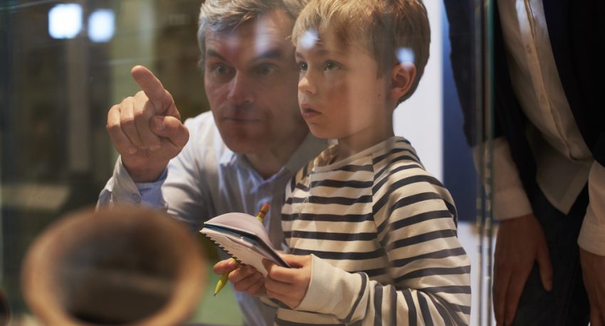 father and son looking at artefacts in museum miami